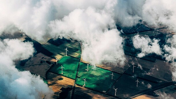 Bild von einem Windpark aus der Vogelperspektive mit Wolken